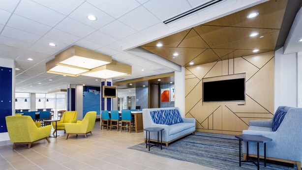 A modern lobby with seating areas, a flat-screen TV, and a reception desk. - Holiday Inn Express & Suites Tampa Stadium – Airport Area by IHG (Tampa)