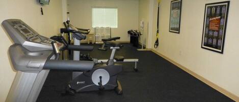 A gym with treadmills, stationary bikes, and exercise equipment.