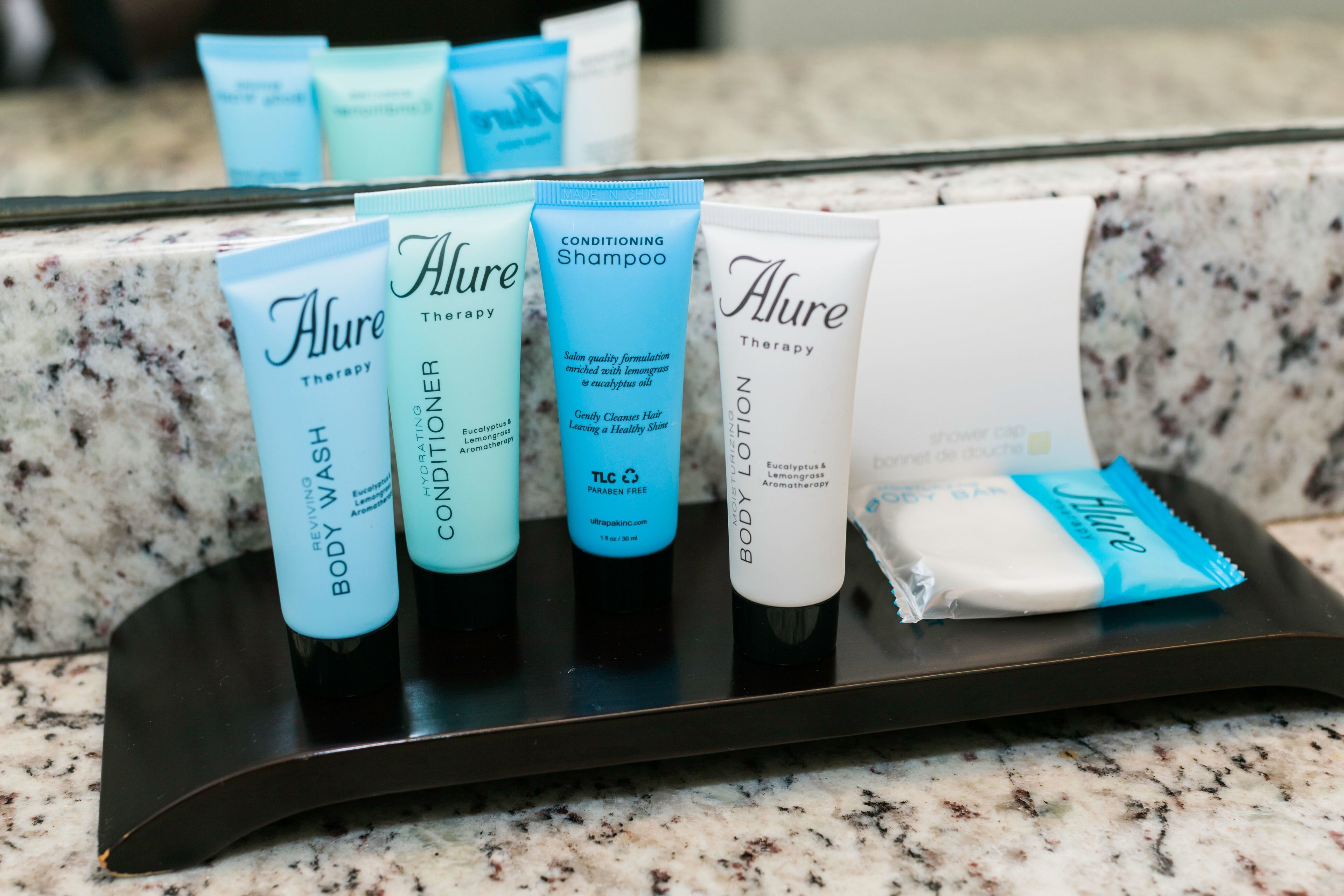 A tray with various toiletries including body wash, conditioner, shampoo, and lotion.