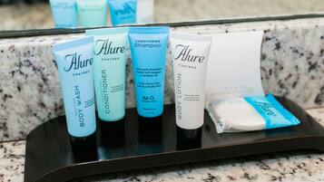 A tray with various toiletries including body wash, conditioner, shampoo, and lotion.