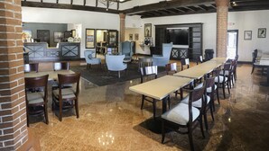 A spacious lobby with a reception desk, seating area, and a large fireplace. - The Flagler Inn (St. Augustine)