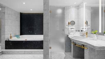 A modern bathroom with a bathtub, a large mirror, and a vanity with a sink.