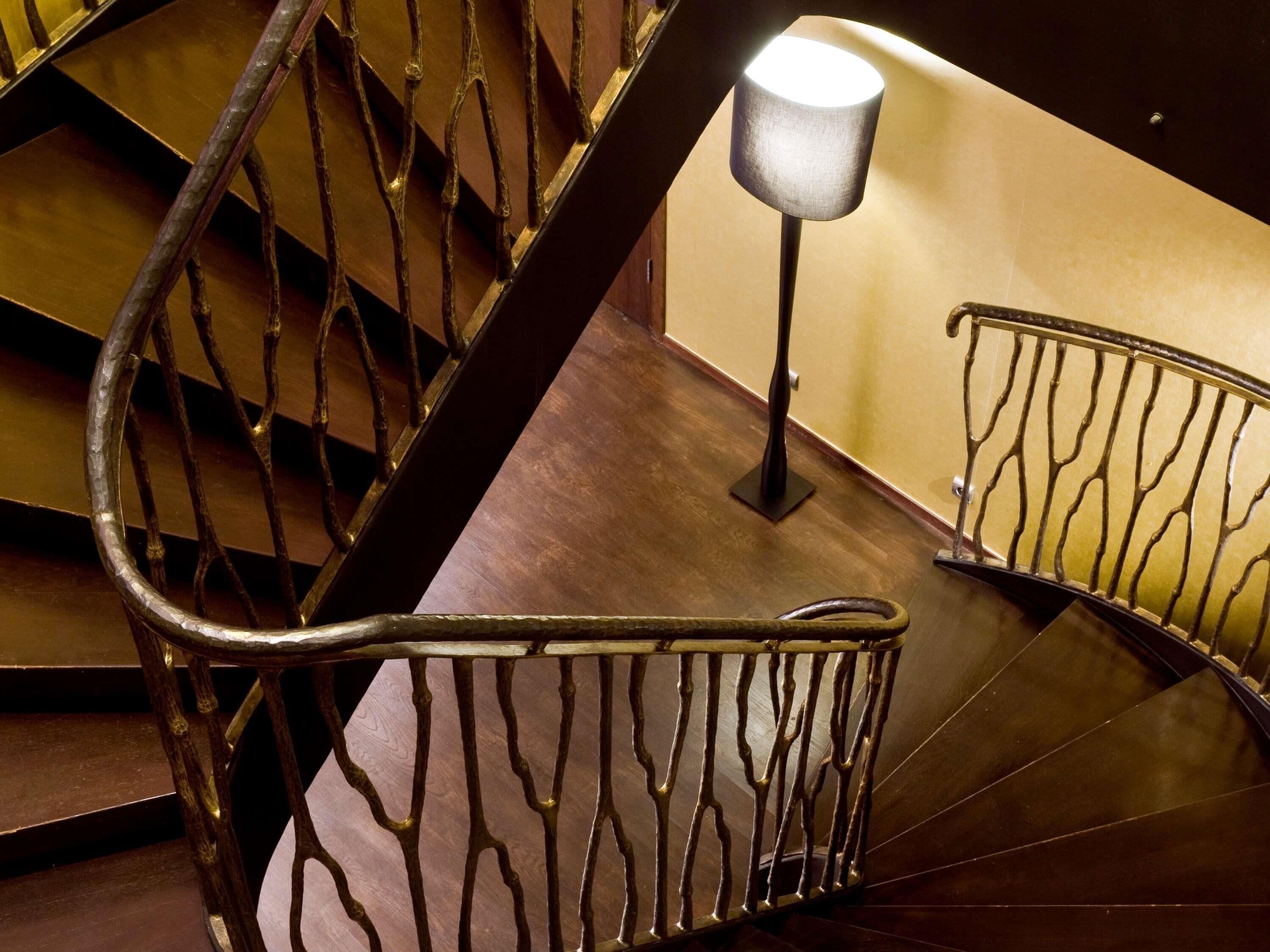A staircase with metal railings and a floor lamp.