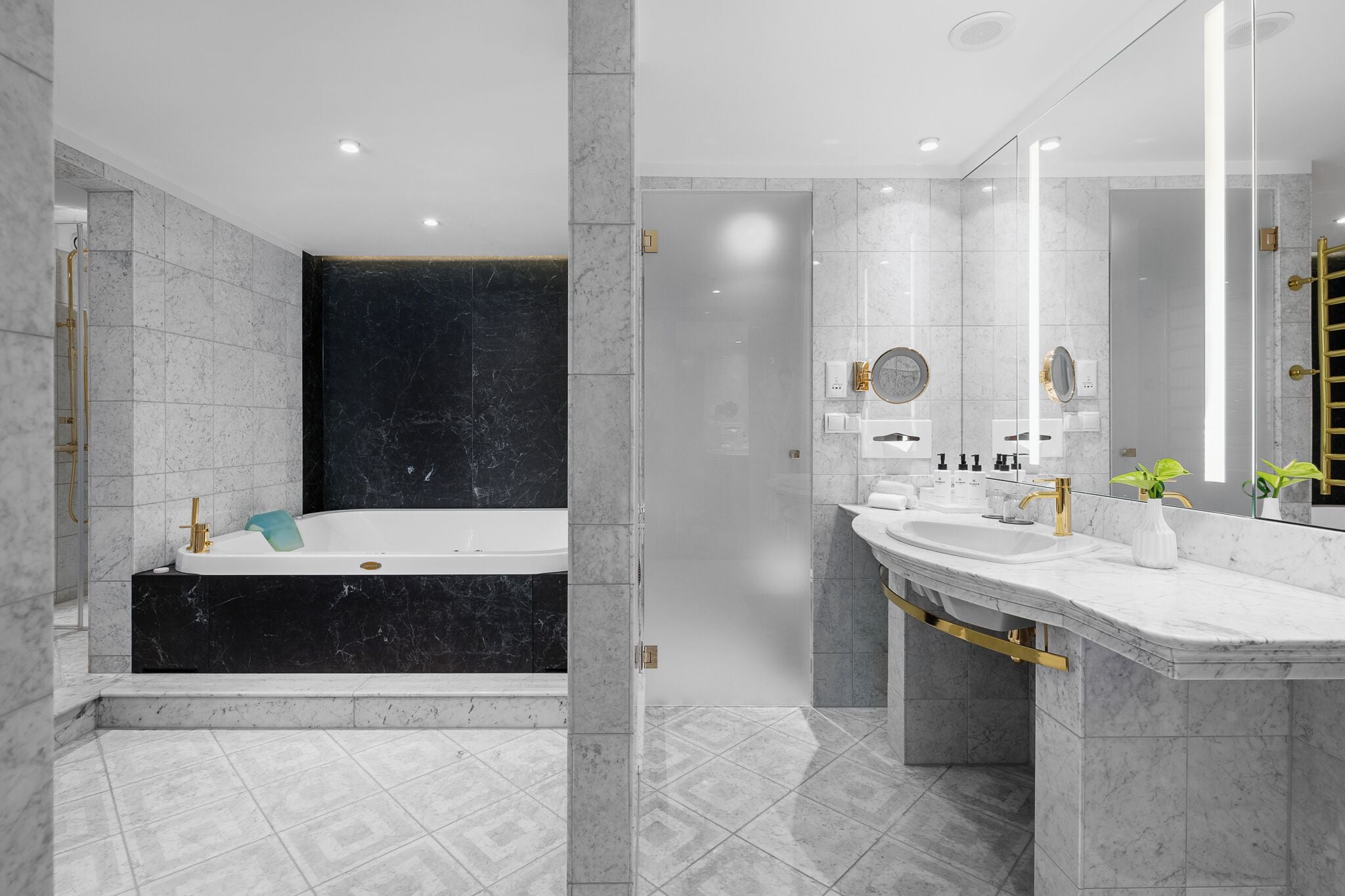 A modern bathroom with a large bathtub, a vanity with a mirror, and a shower area.