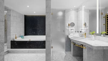 A modern bathroom with a large bathtub, a vanity with a mirror, and a shower area.