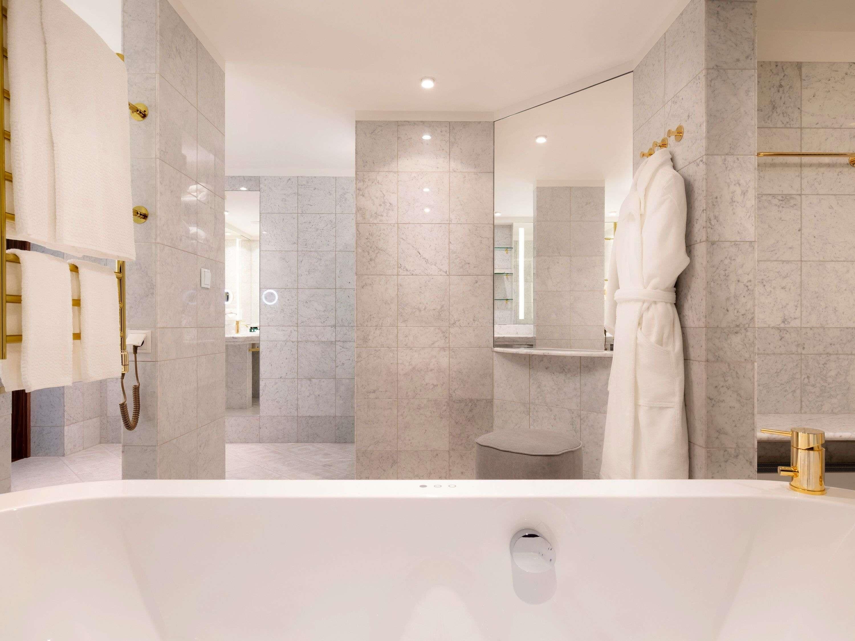 A modern bathroom with a bathtub, a shower area, and a vanity with a mirror.