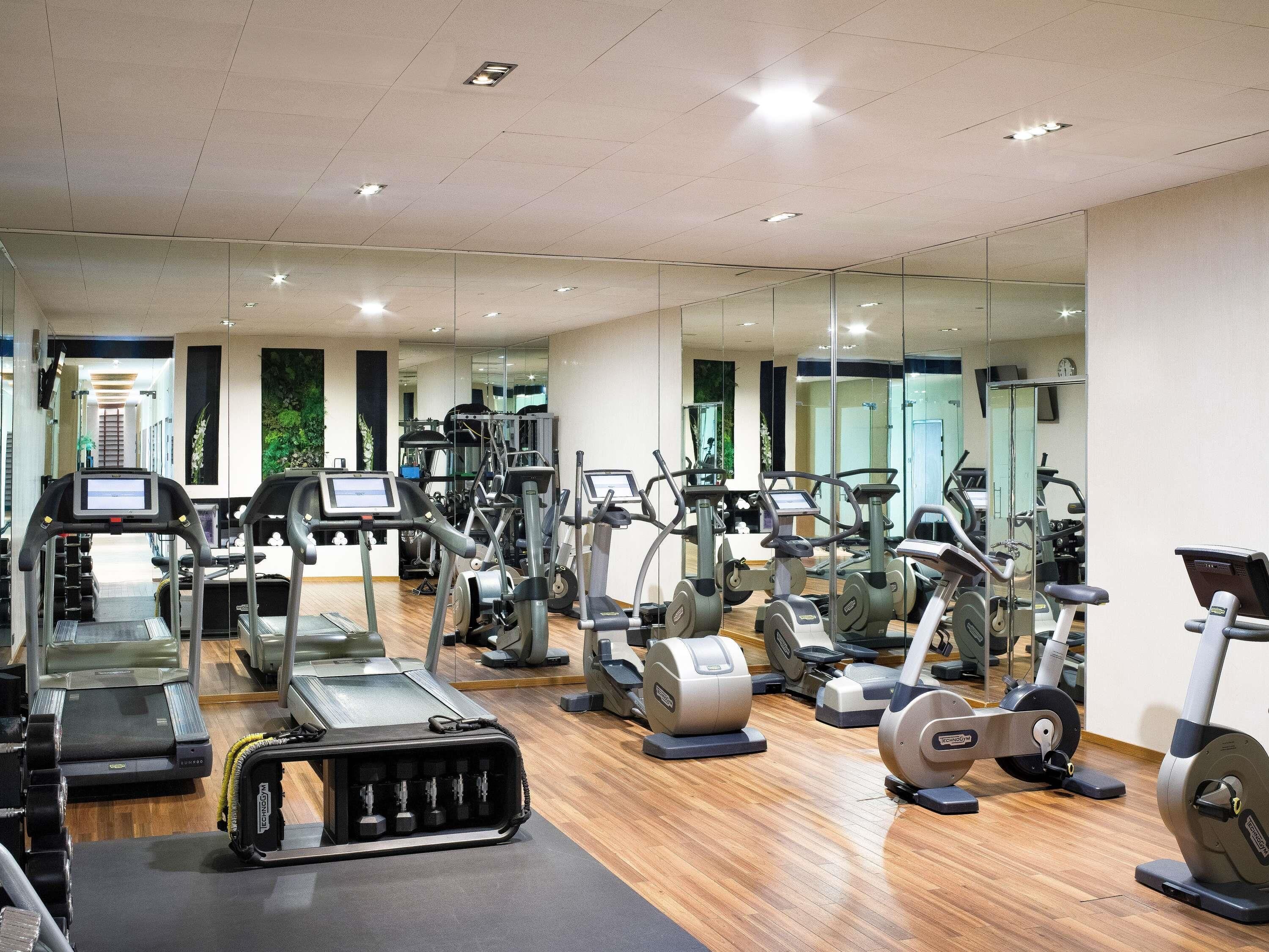 Ein Fitnessstudio mit Laufbändern, Crosstrainern und Kraftgeräten.