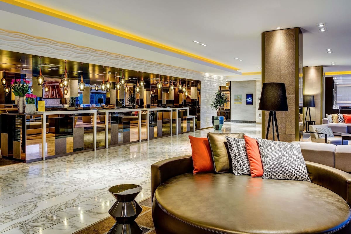 A modern lobby with a seating area, a reception desk, and a bar.