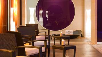 Un coin salon avec des fauteuils en osier et un miroir rond.