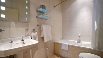 A bathroom with a sink, mirror, towel rack, and a bathtub.