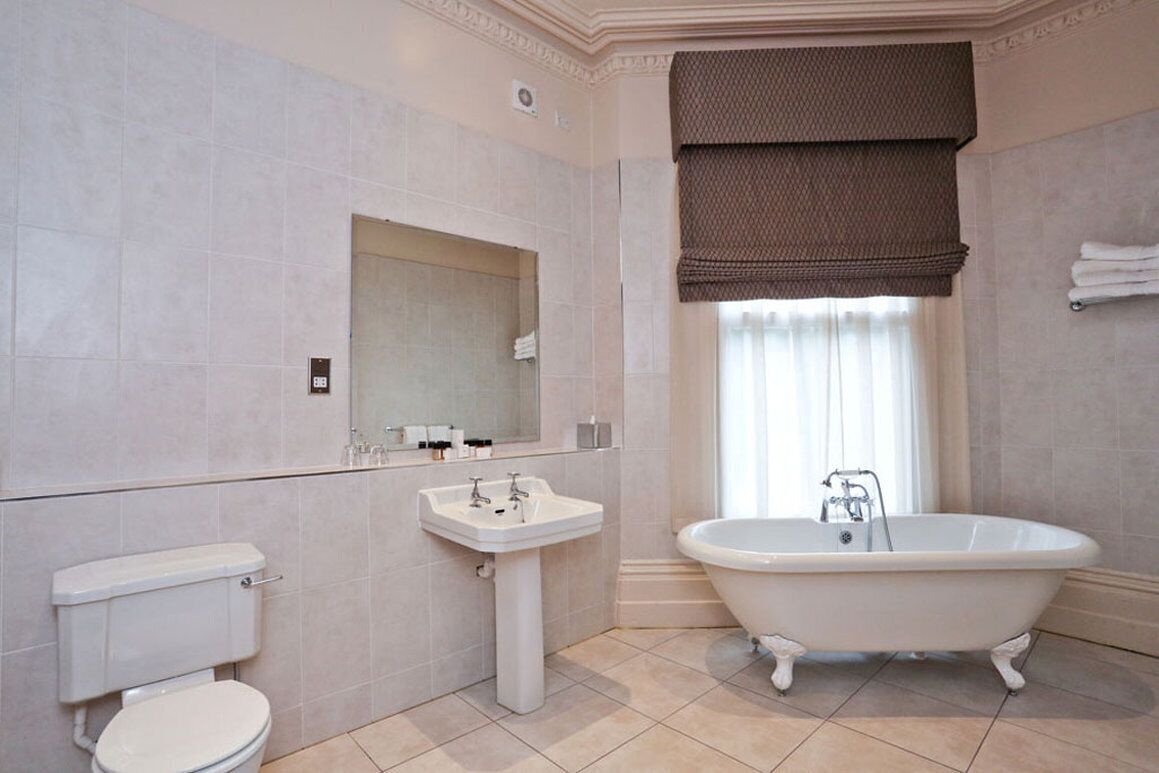 Een badkamer met toilet, wastafel en een vrijstaand bad.