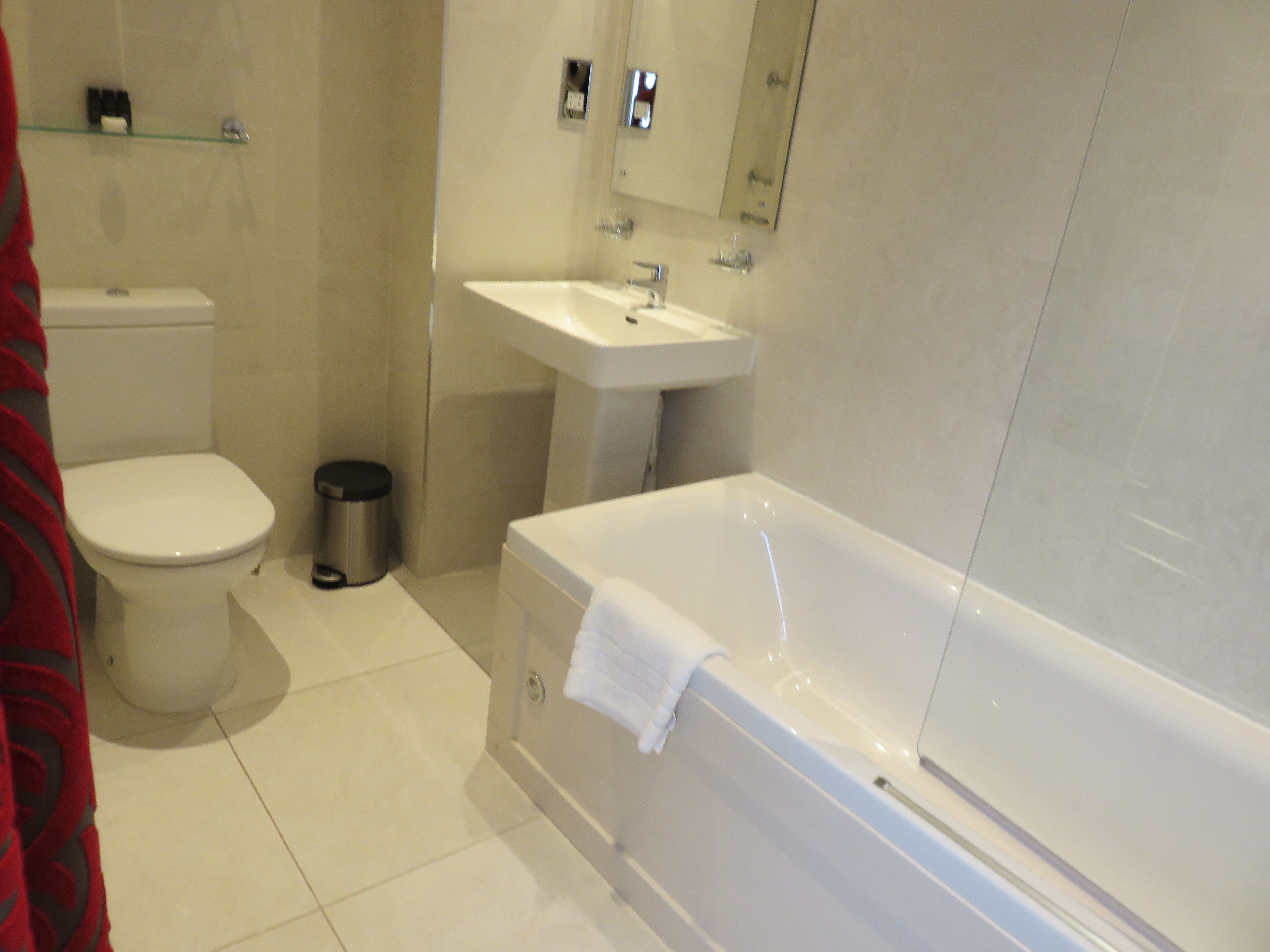 A modern bathroom with a toilet, sink, and bathtub.