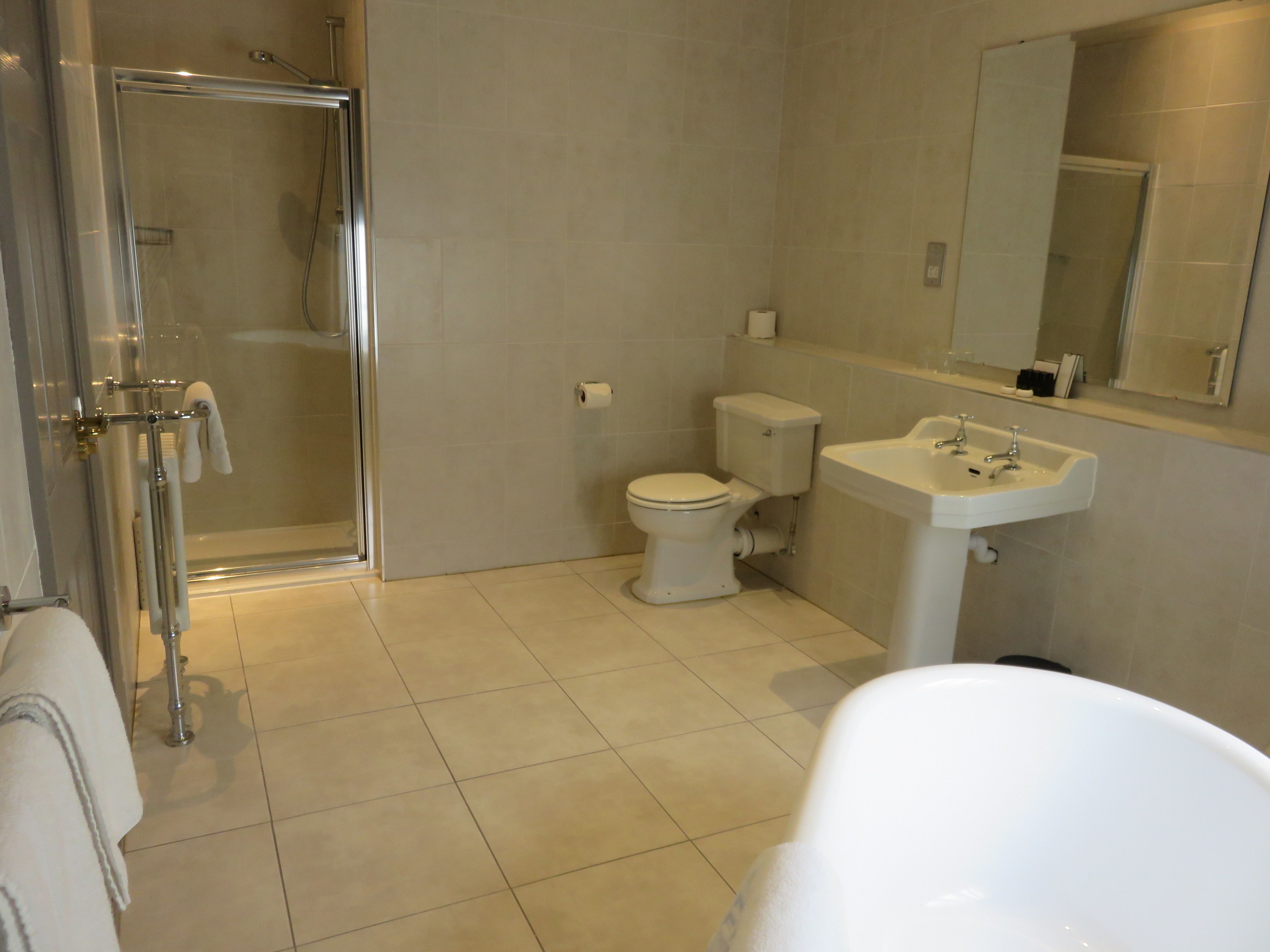 Un baño con ducha de vidrio, inodoro y lavamanos.