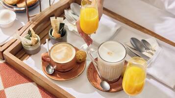 Una bandeja de desayuno con una taza de café, un vaso de jugo de naranja y una taza de leche.