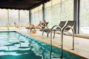 A swimming pool area with lounge chairs and a covered seating area. - Van der Valk Hotel Antwerpen (Antwerp)