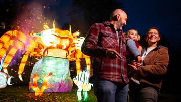 Une famille se tient devant une grande sculpture illuminée.