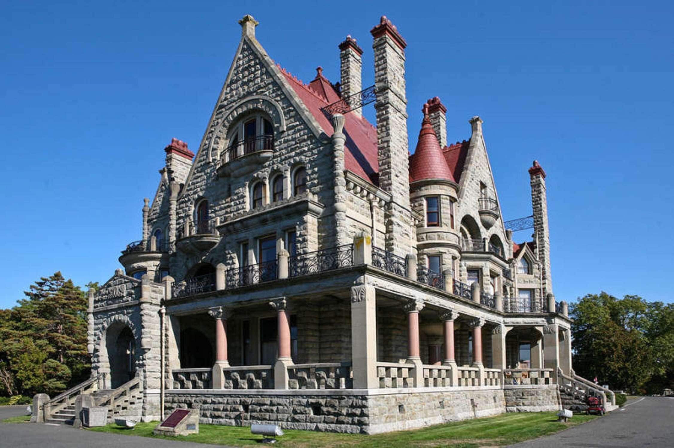 A large, ornate stone building with multiple towers and a red roof.