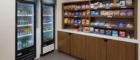 A Bright Side Market with refrigerated beverage dispensers and snack shelves.