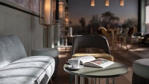 A cozy seating area with a table, a cup, and a book, suggesting a quiet reading or dining space.