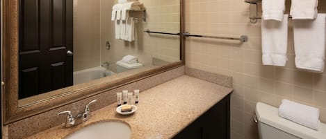 A bathroom with a sink, mirror, towel rack, and toilet.