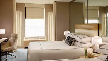 Ein Hotelzimmer mit zwei Betten, einem Schreibtisch und einem Stuhl.