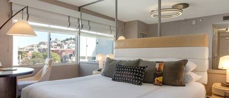 Una habitación de hotel moderna con una cama grande, un escritorio y vistas a la ciudad.