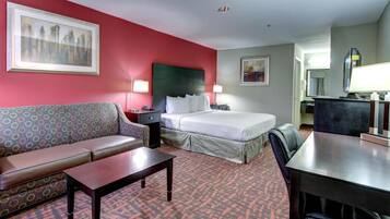 Une chambre d’hôtel avec un lit, un canapé, un bureau et une chaise.