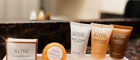 A display of essential elements bath products on a marble countertop.