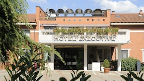 A hotel entrance with a sign reading "HOTEL EXPO". - Hotel Executive (Siena)