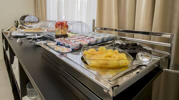 Ein reichhaltiges Buffet mit verschiedenen Speisen, darunter Obst, Joghurts und Gebäck.