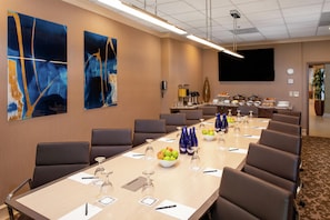 A conference room with a long table, chairs, and various amenities like a coffee station and a clock on the wall. - Hilton San Diego Airport/Harbor Island (San Diego)