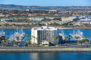 A marina with numerous boats, a Hilton hotel, and a view of the surrounding cityscape. - Hilton San Diego Airport/Harbor Island (San Diego)