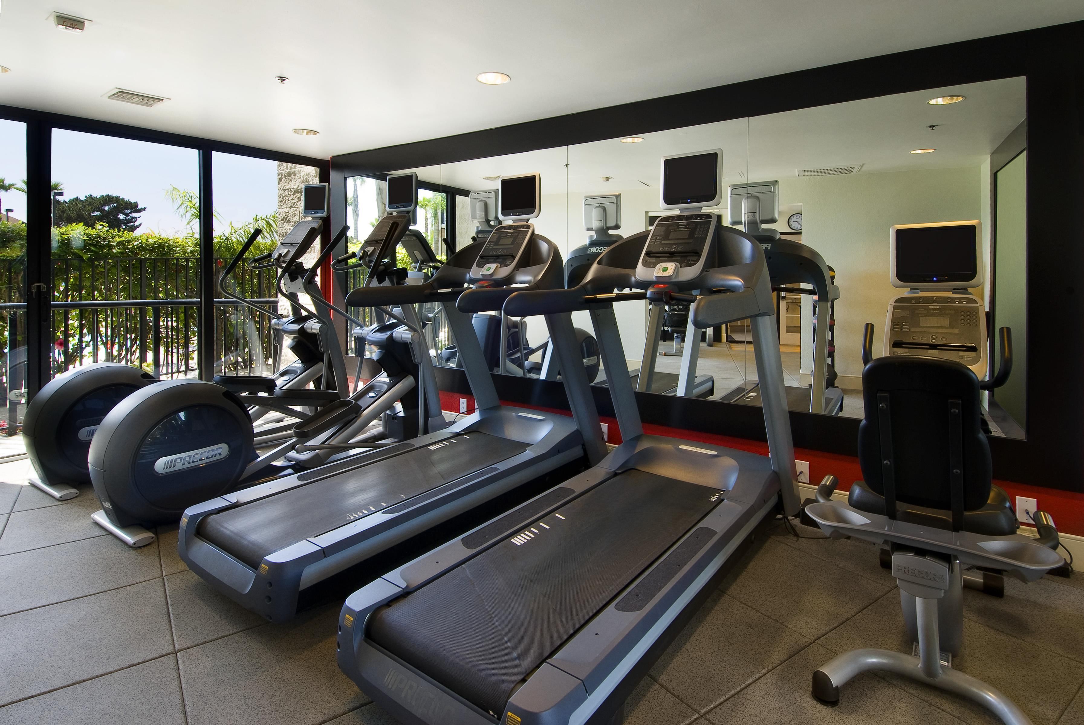 A gym with treadmills, elliptical machines, and weight equipment.