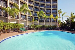 A hotel with a large pool, palm trees, and a multi-story building with balconies. - Hilton San Diego Airport/Harbor Island (San Diego)