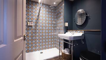 A bathroom with a patterned tile wall, a bathtub, a sink, and a toilet.