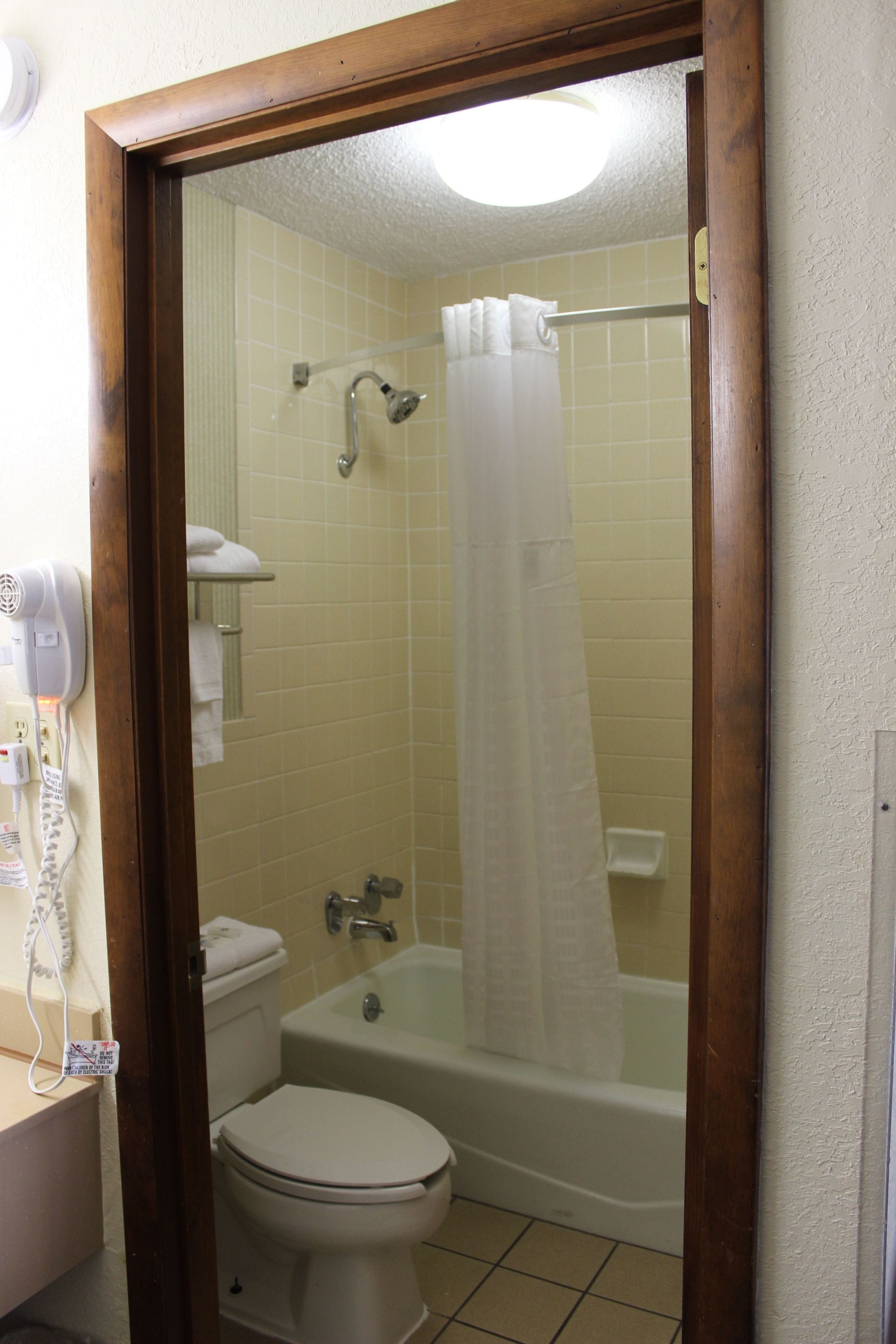 A bathroom with a toilet, a bathtub, and a shower curtain.