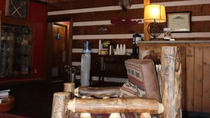 A rustic interior with wooden walls, a wooden bench, and a chandelier. - Great Smokies Inn Cherokee (Cherokee)