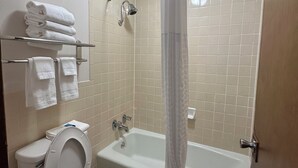 A bathroom with a toilet, sink, and bathtub with a shower curtain.