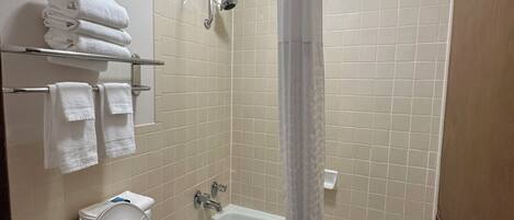 Un baño con inodoro, lavabo y bañera con cortina de ducha.