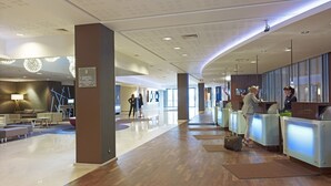 A spacious lobby with a reception desk, seating area, and a modern chandelier. - Novotel Warszawa Centrum (Warsaw)