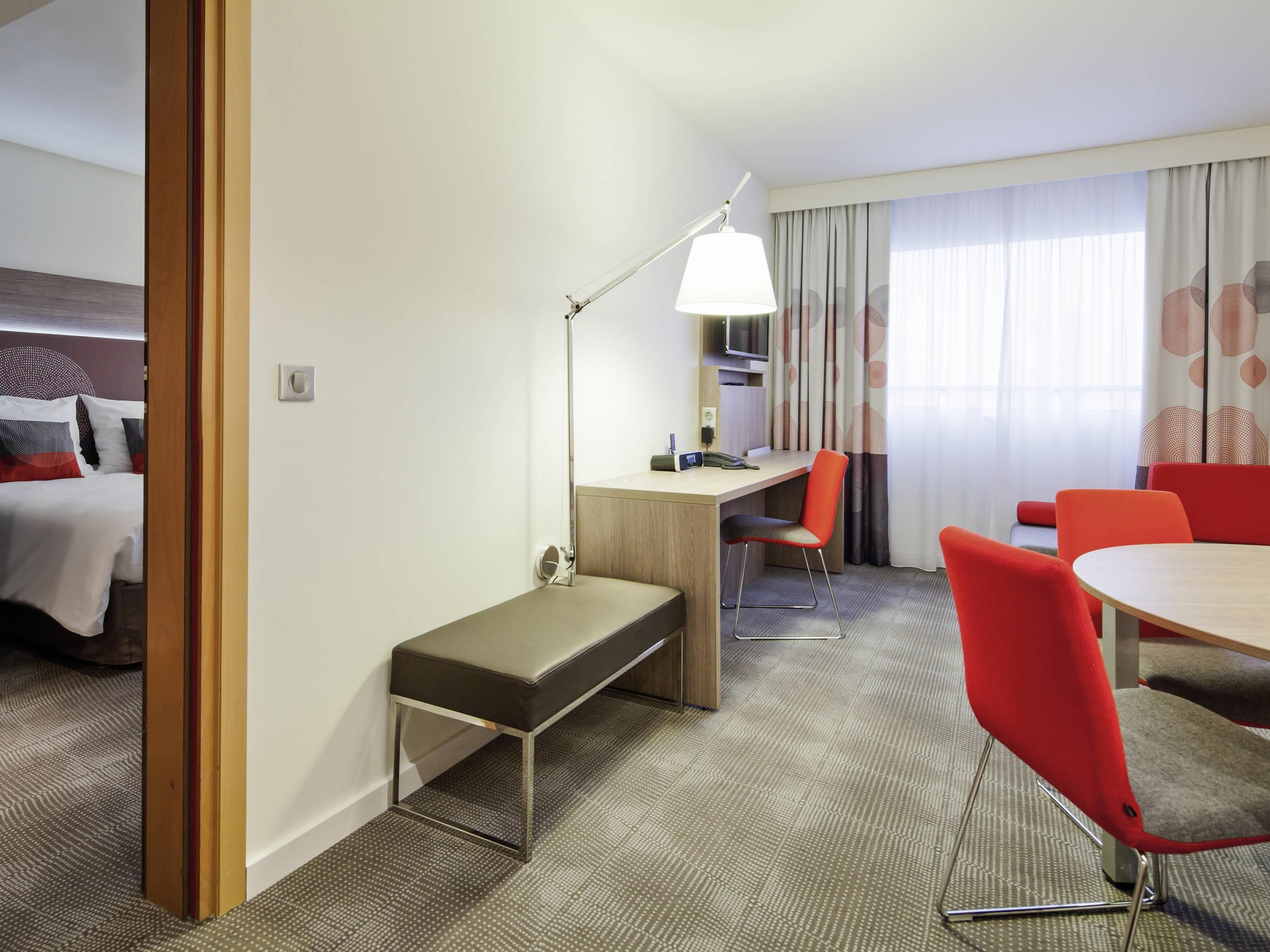 Una habitación de hotel con cama, escritorio, silla y mesa.