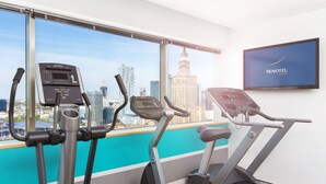 A gym with exercise equipment and a city view. - Novotel Warszawa Centrum (Warsaw)