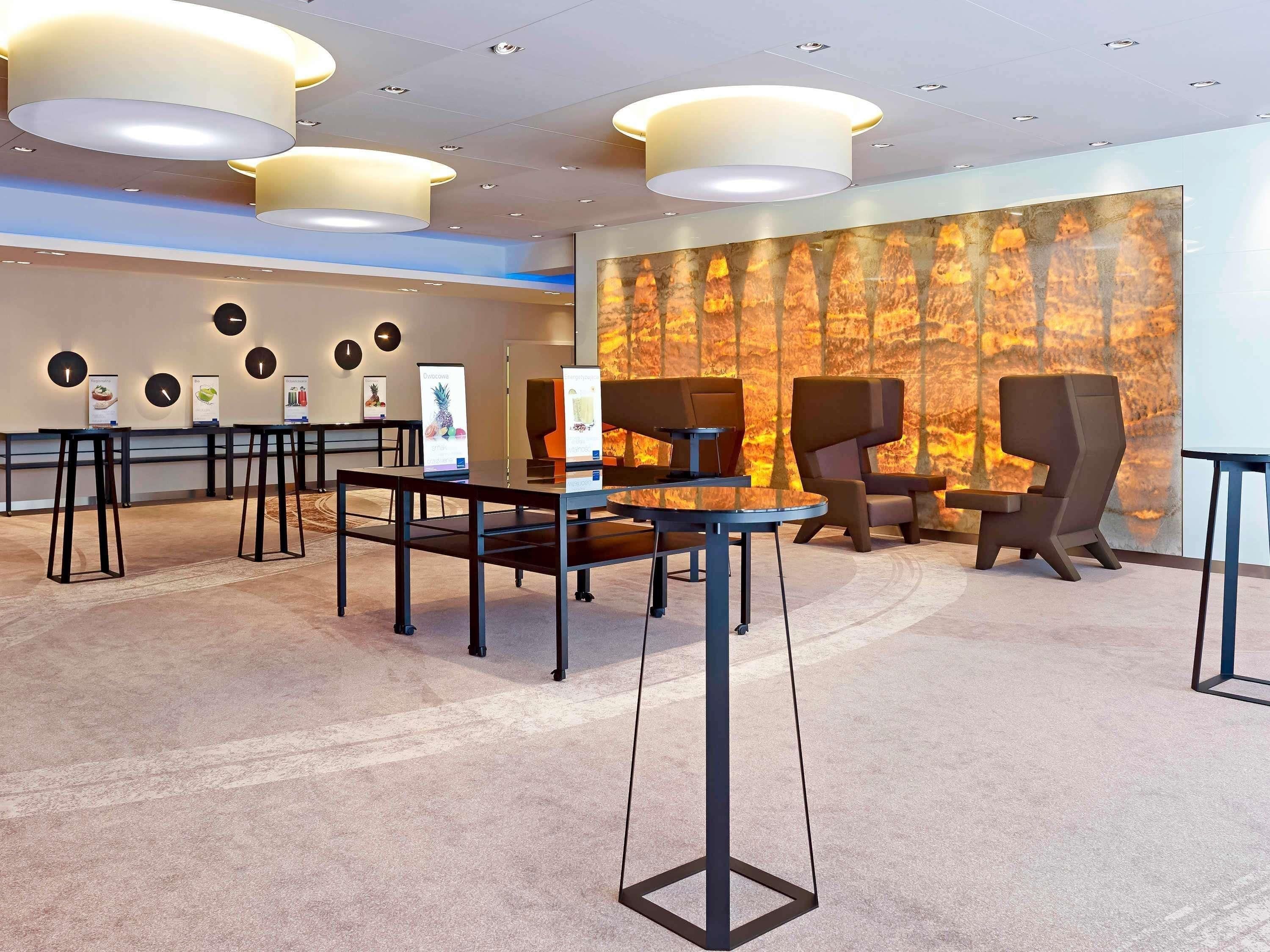 Eine moderne Lobby mit einer Rezeption, einer Sitzecke und einem großen Wandgemälde.