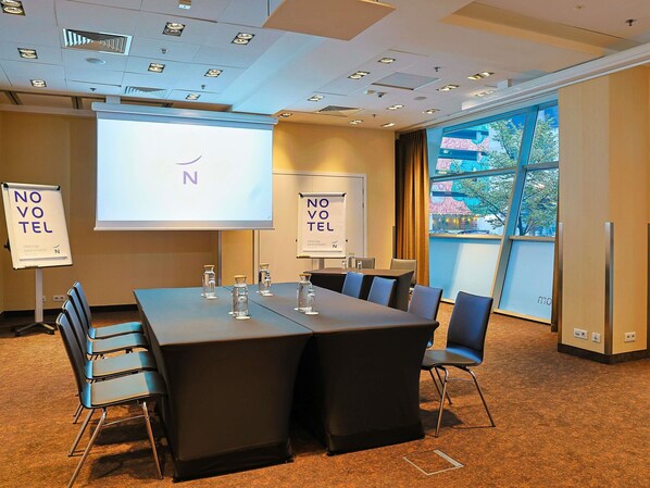 A conference room with a large table, chairs, a projector screen, and two 'NO VOTE' signs. - Novotel Warszawa Centrum (Warsaw)