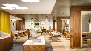 A modern dining area with hexagonal ceiling lights, wooden paneling, and a central serving station.