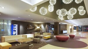 A modern lobby with a sofa, tables, and a TV. - Novotel Warszawa Centrum (Warsaw)