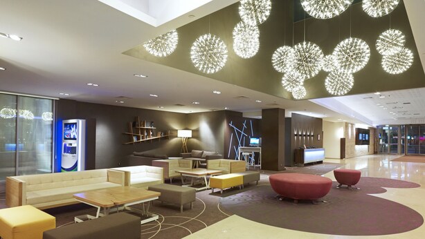 A modern lobby with a sofa, tables, and a TV. - Novotel Warszawa Centrum (Warsaw)