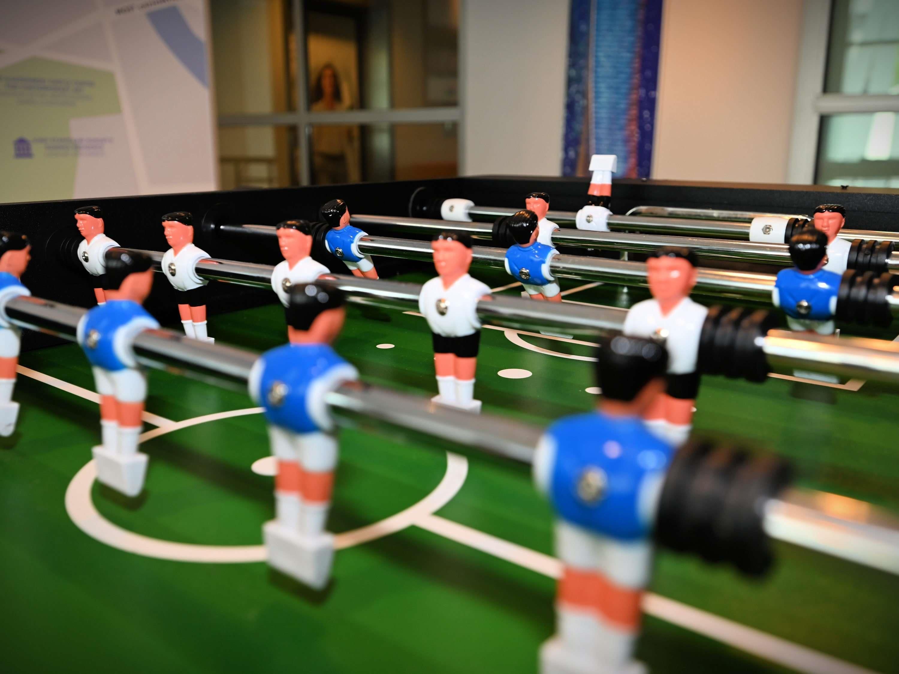 Een tafelvoetbaltafel met meerdere spelers.