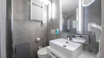 A modern bathroom with a toilet, sink, and shower.