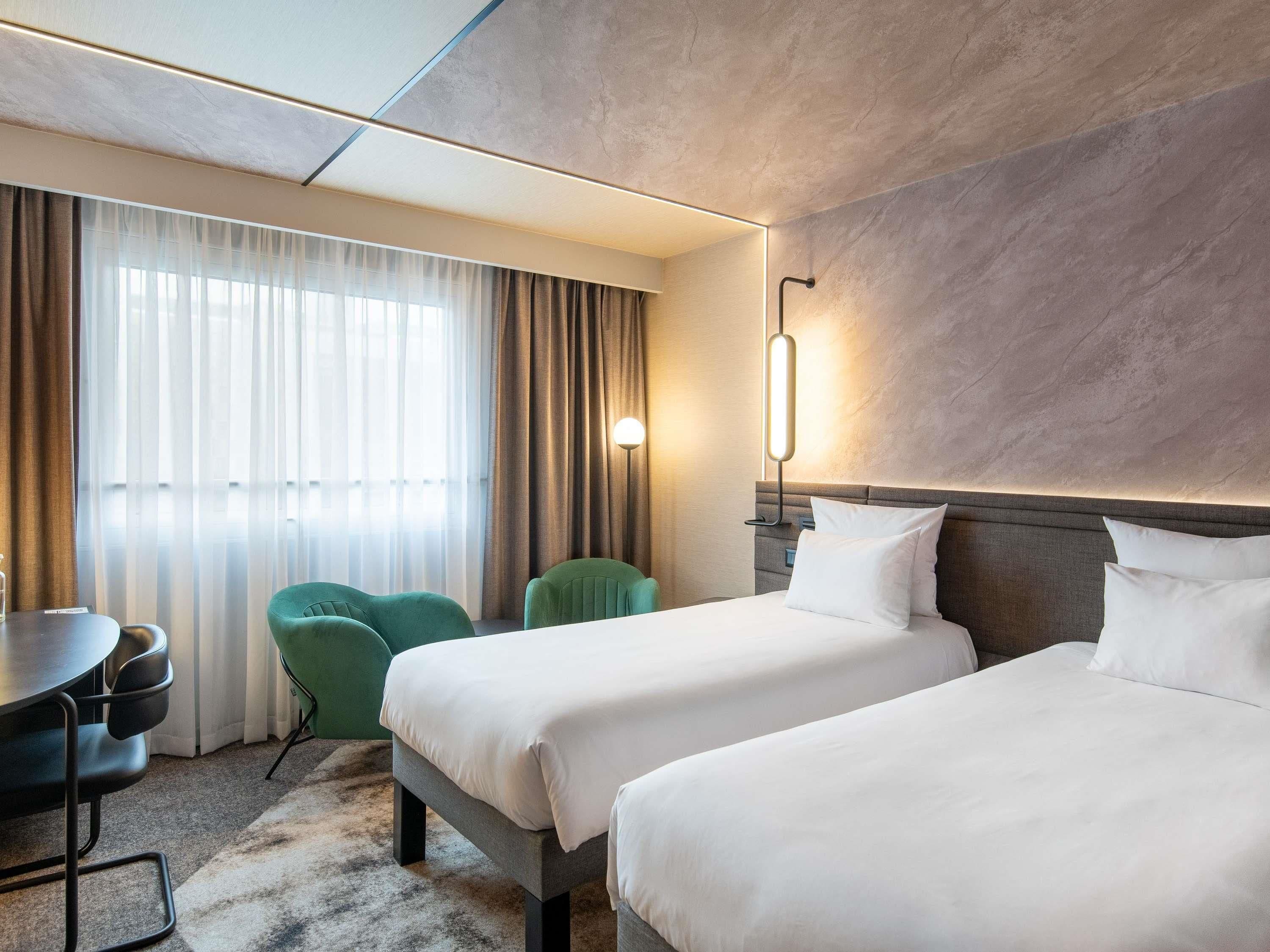 Una habitación de hotel con dos camas, un escritorio y una silla.